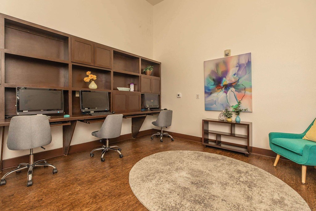 A room with a desk, chairs, and a painting on the wall at The Villages at Lost Creek Apartments, San Antonio, 78247