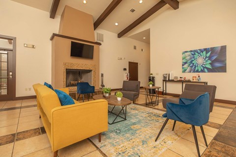 A living room with a yellow couch and a fireplace.