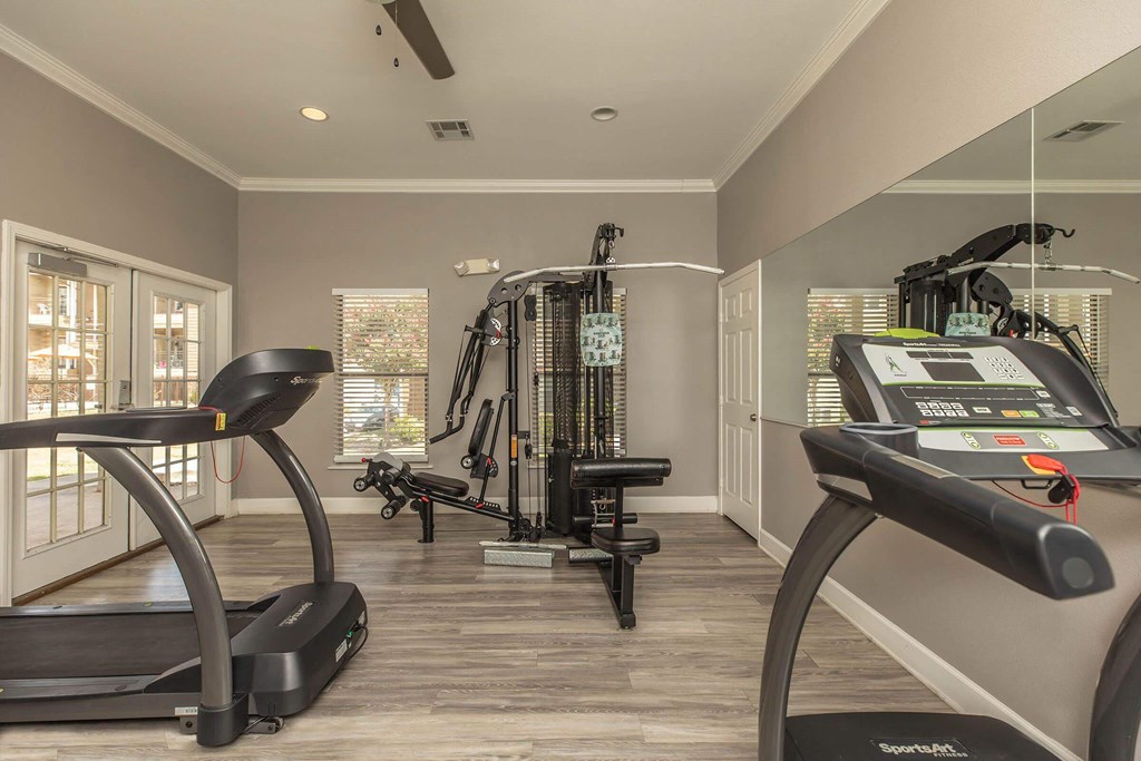 A spacious gym with treadmills, elliptical machines, and other exercise equipment at The Villages at Lost Creek Apartments, Texas, 78247