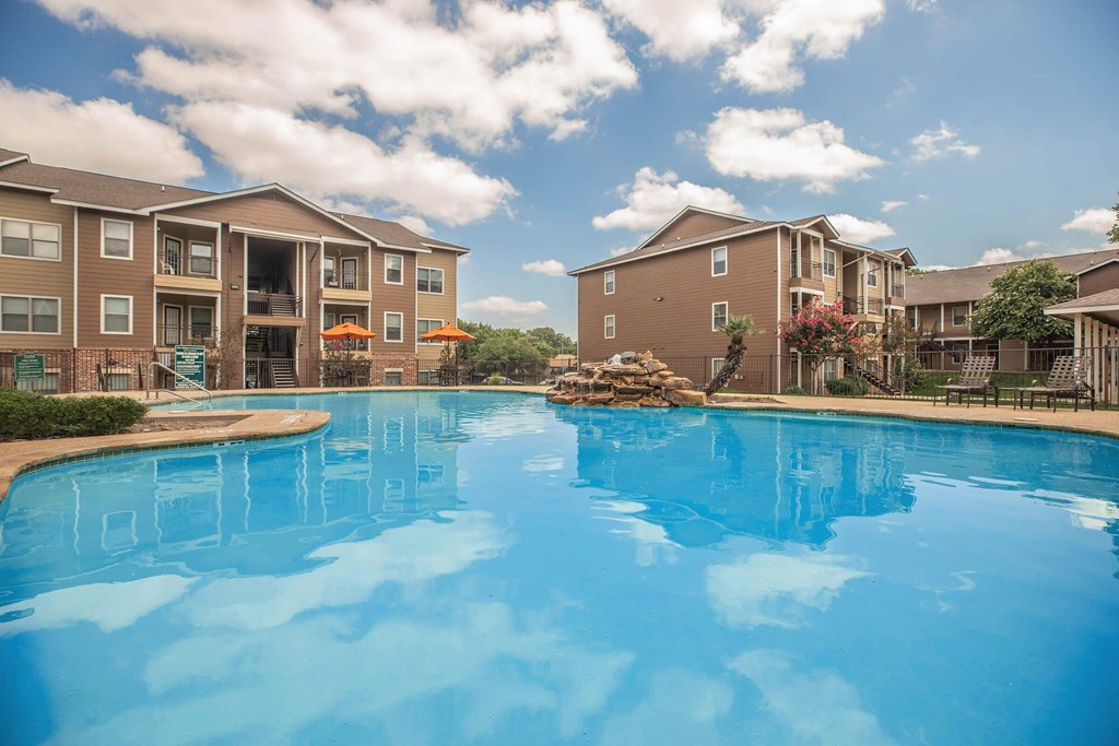 A large swimming pool in front of apartment buildings at The Villages at Lost Creek Apartments, San Antonio, TX, 78247