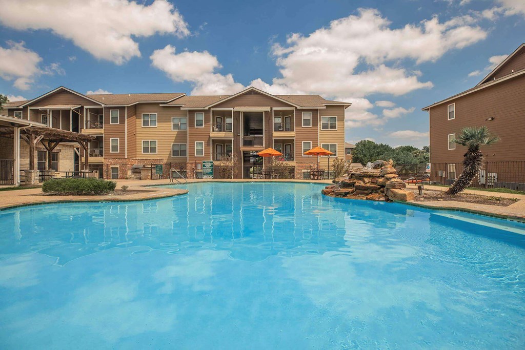 A large swimming pool in front of apartment buildings at The Villages at Lost Creek Apartments, San Antonio