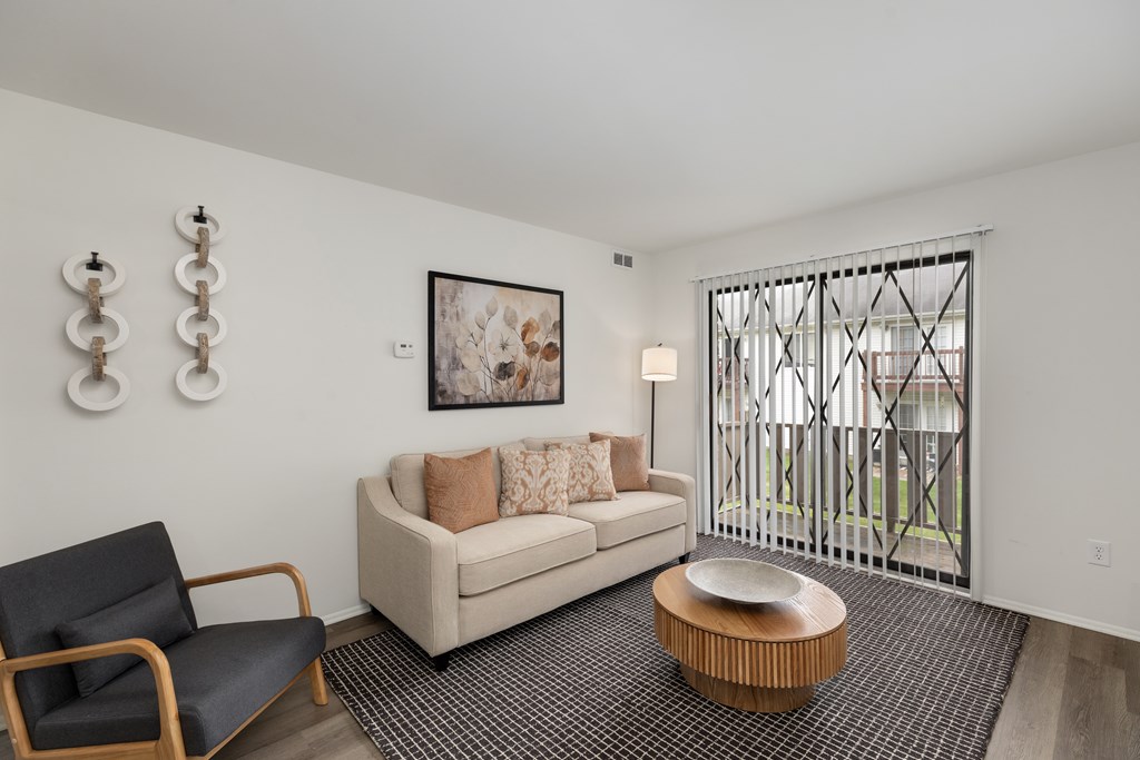 A living room with a couch, chair, and a painting on the wall.