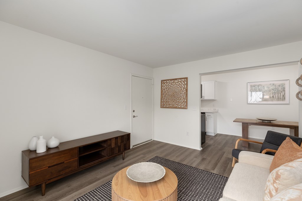 A living room with a brown wooden coffee table and a white sofa.