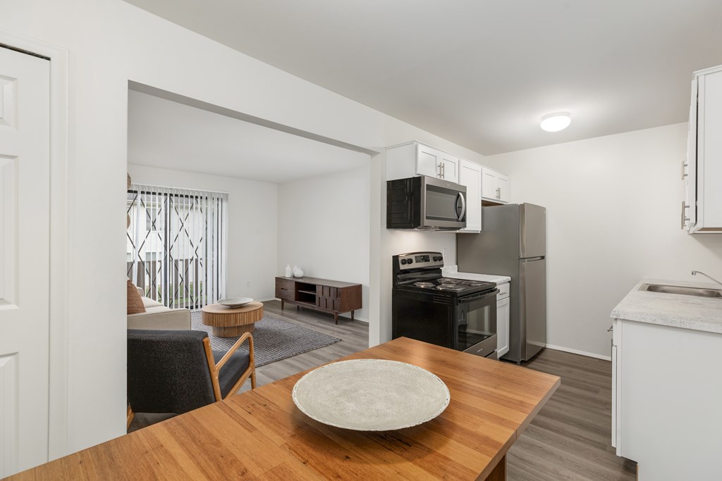 A kitchen with a table and chairs in the foreground.