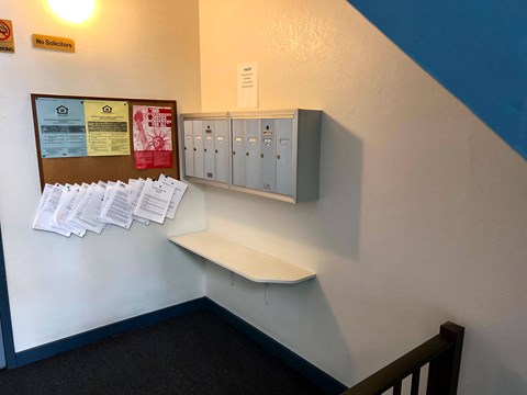 A bulletin board with papers attached to it is on a wall.