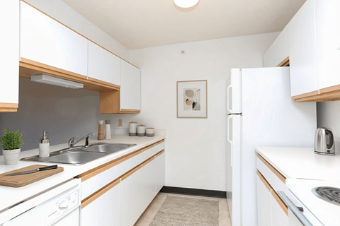 A kitchen with white cabinets and a white fridge.