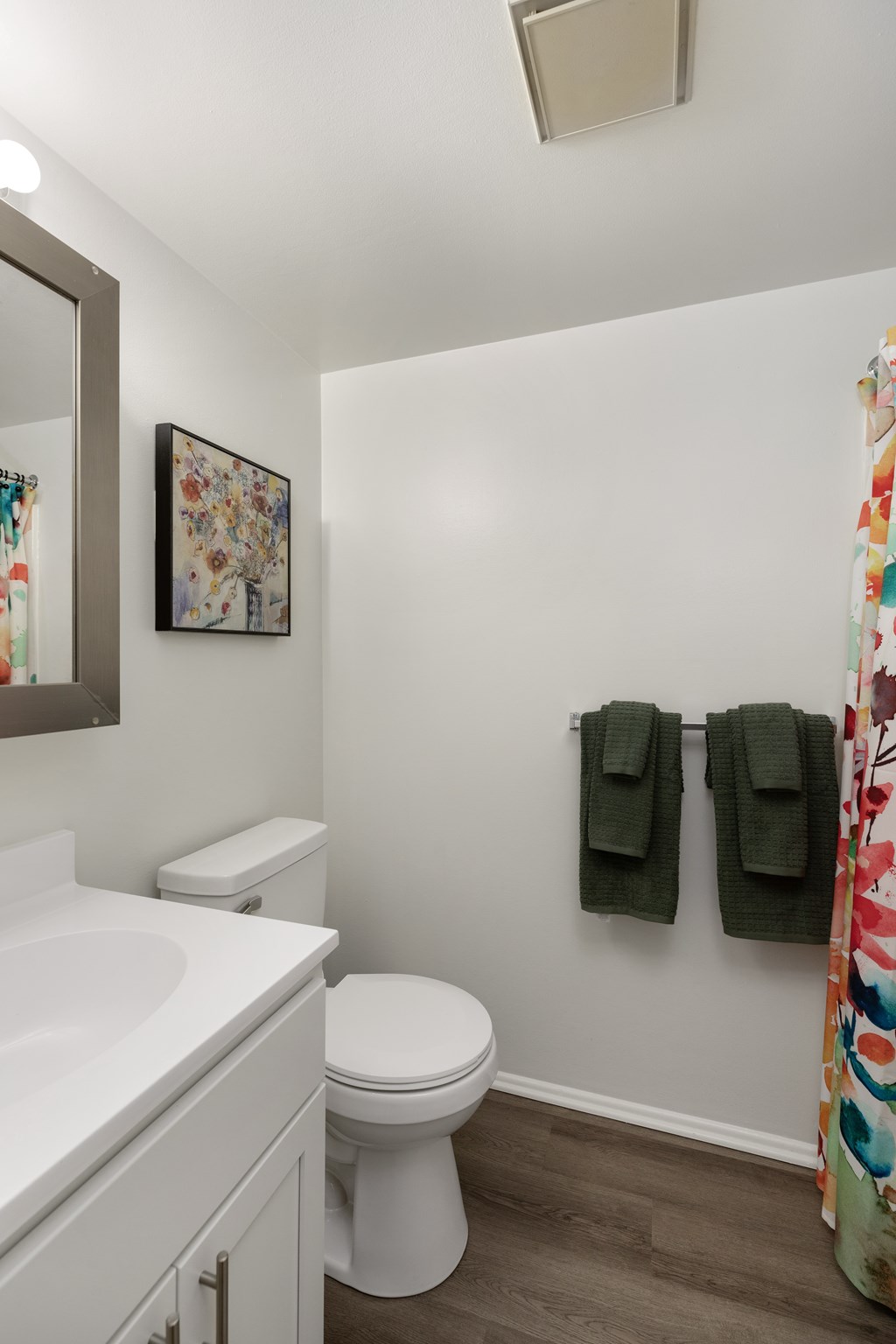 A white toilet sits next to a sink in a small bathroom.