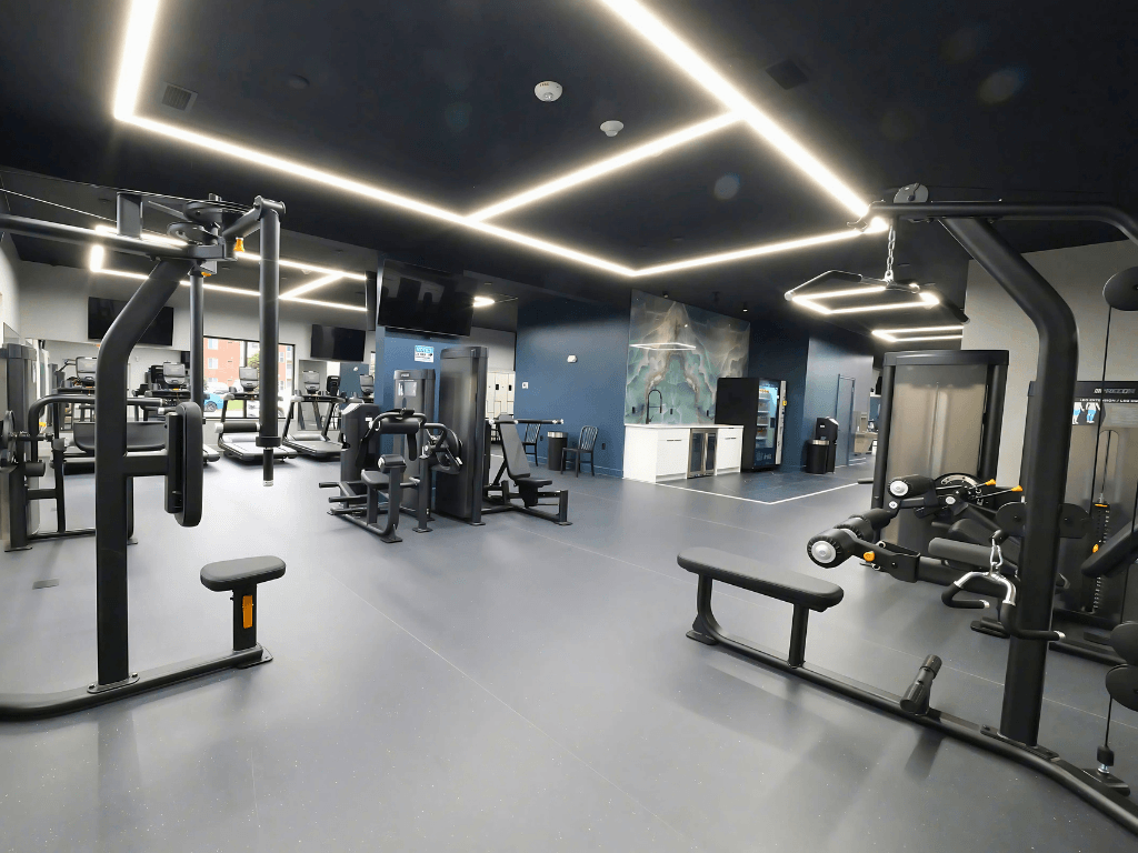 A gym with a variety of equipment and a bench.