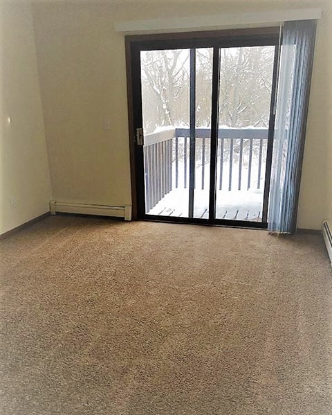 a living room with a sliding glass door to a balcony