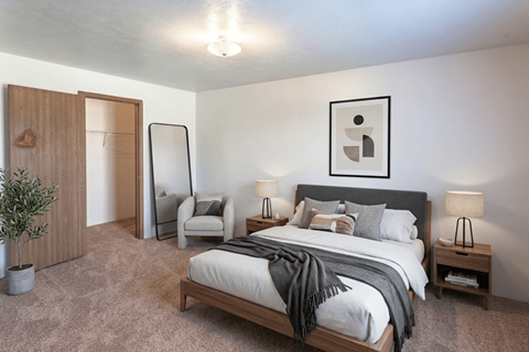 A bedroom with a large bed and a chair.