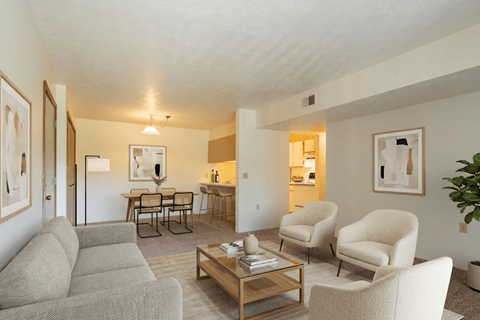 A living room with a grey sofa, two chairs and a coffee table.