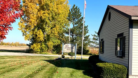 the building where the motel is located is next to a flagpole with a sign
