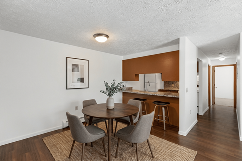 A dining room with a table and chairs.