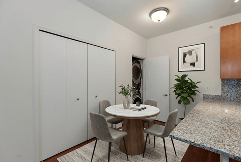 A dining room with a round table and chairs.