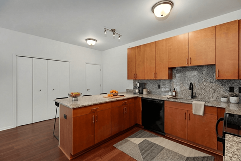 A kitchen with wooden cabinets and a granite countertop.