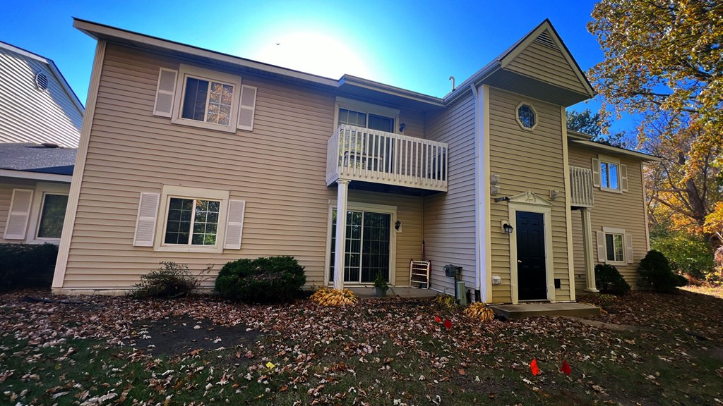 the front of a house with a yard and a deck