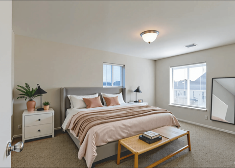 A bedroom with a bed, nightstand, and a plant.