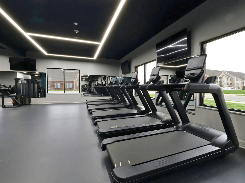A gym with treadmills and a television.