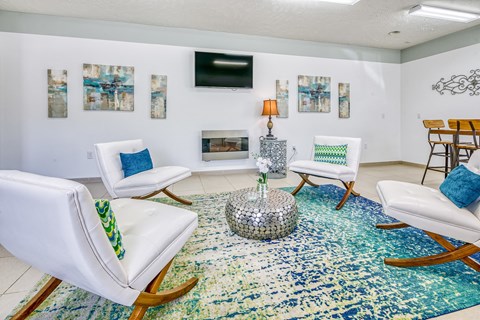 a living room with white chairs and a rug and a fireplace