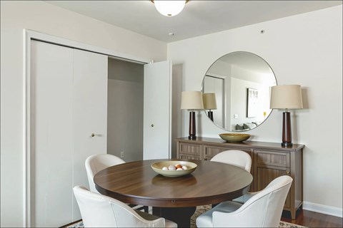 A dining room with a round table and chairs.