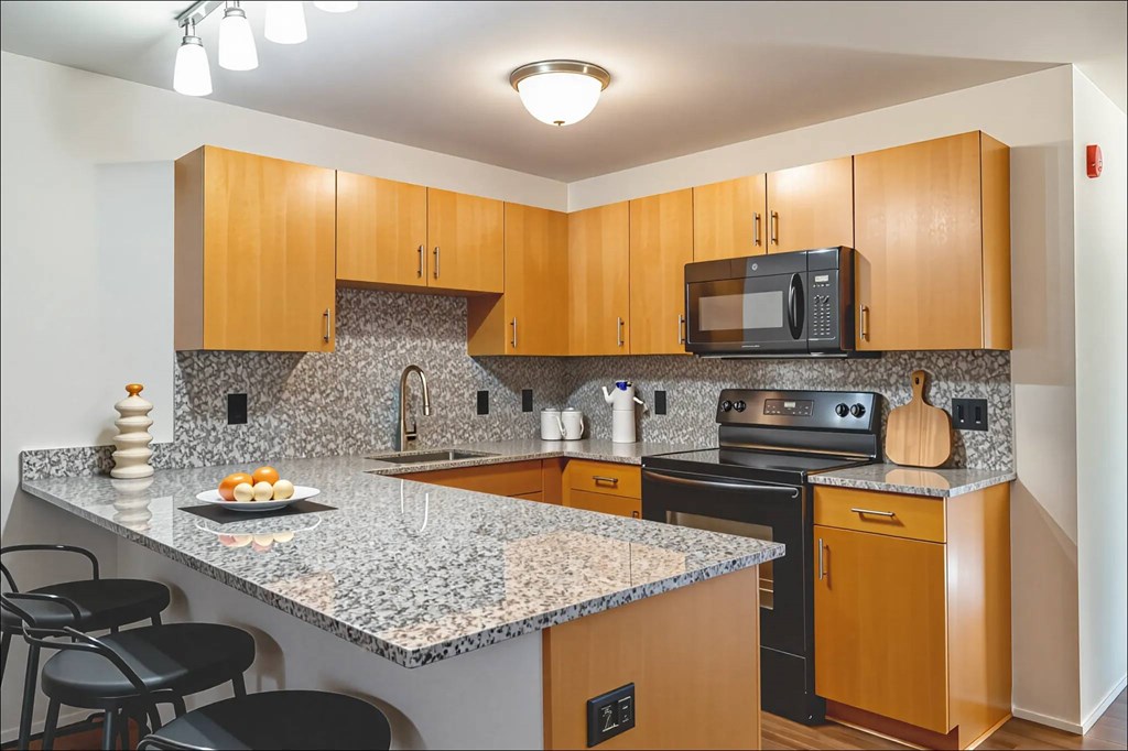 A kitchen with wooden cabinets and granite countertops.