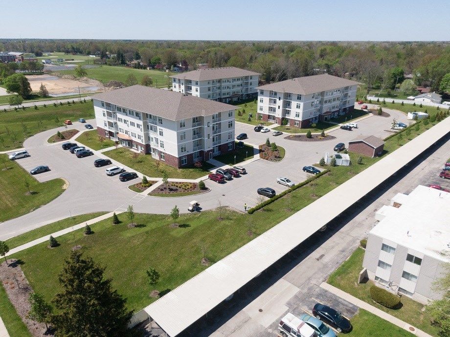 an aerial view of three apartment buildings and a parking lot