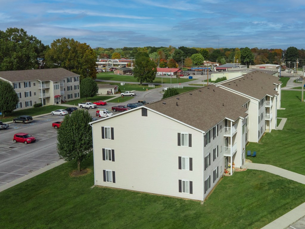 an aerial view of an apartment complex with a parking lot