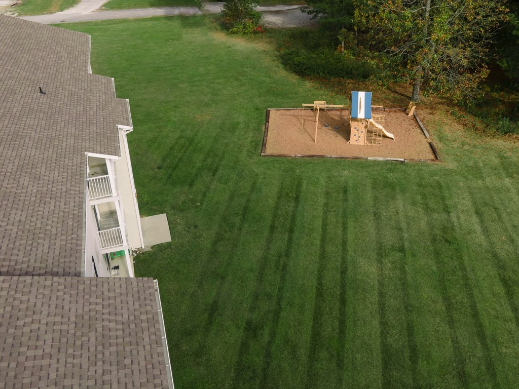 a view of the back yard from the roof of a house with a backyard playground