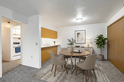 A dining room with a round table and chairs.