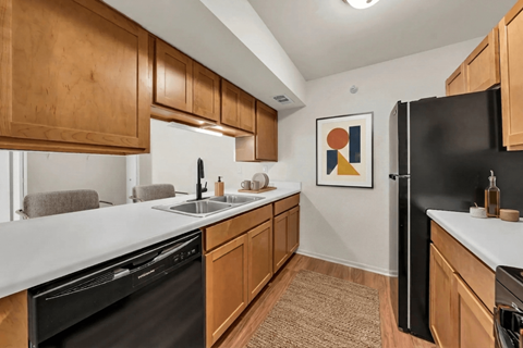 A kitchen with wooden cabinets and black appliances.