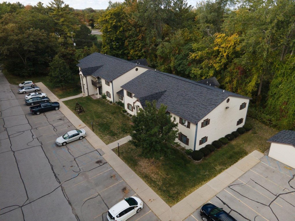 an aerial view of a white house and a parking lot