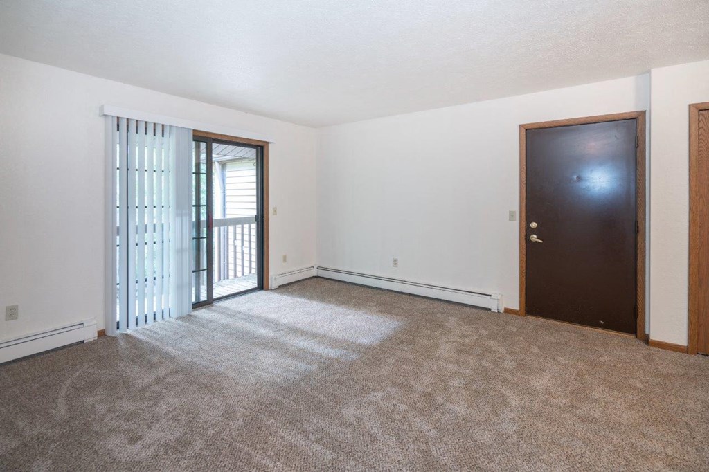 an empty living room with a door to a balcony