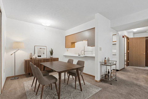 A modern dining room with a wooden table and chairs.