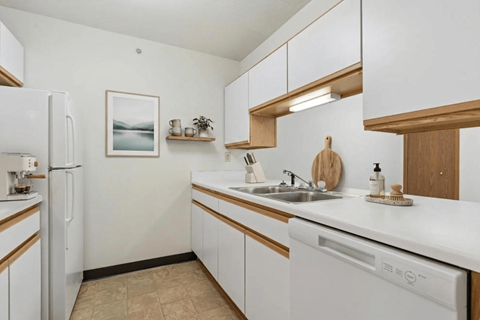 A kitchen with white appliances and wooden accents.