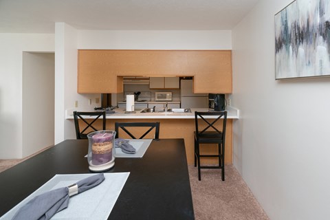 a kitchen and dining room with a black table and chairs