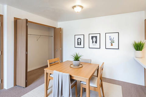 A dining room with a table and chairs.