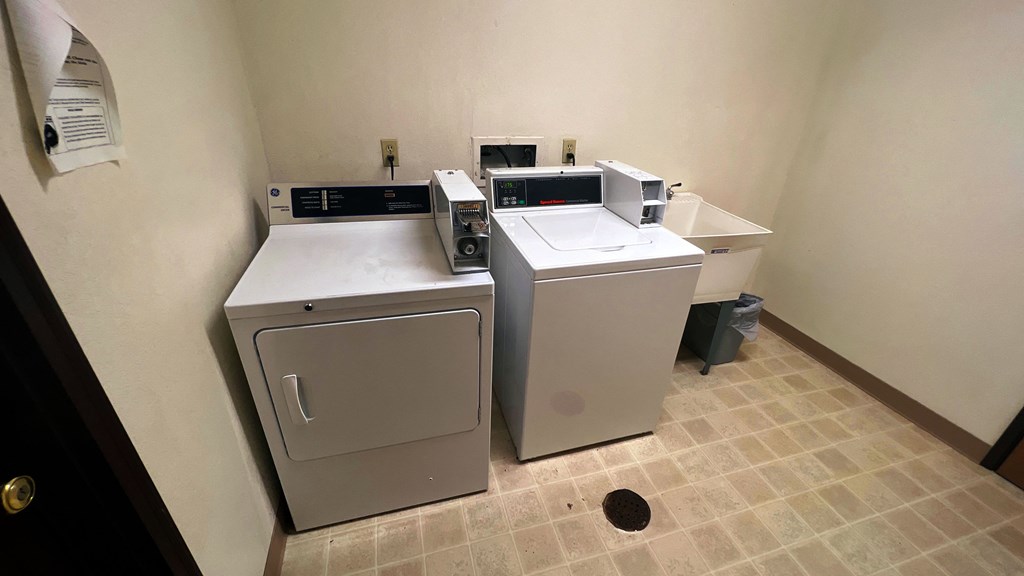 a laundry room with two washing machines and a sink