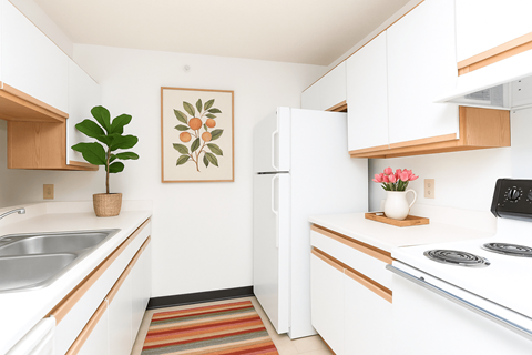 A kitchen with white cabinets and a white fridge.