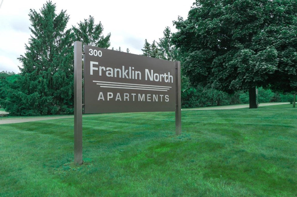 a sign apartments in the middle of a field
