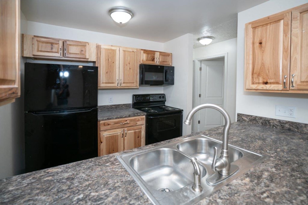 a kitchen with black appliances and granite counter tops