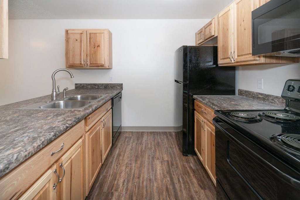 a kitchen with granite counter tops and black appliances