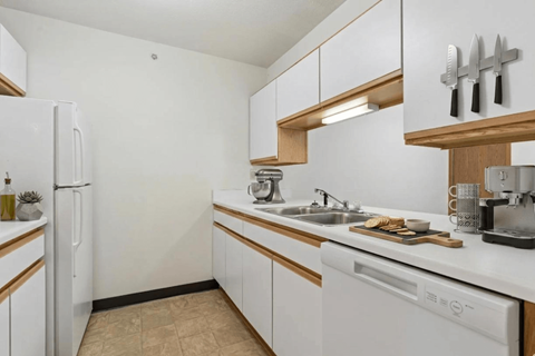 A kitchen with white appliances and wooden accents.