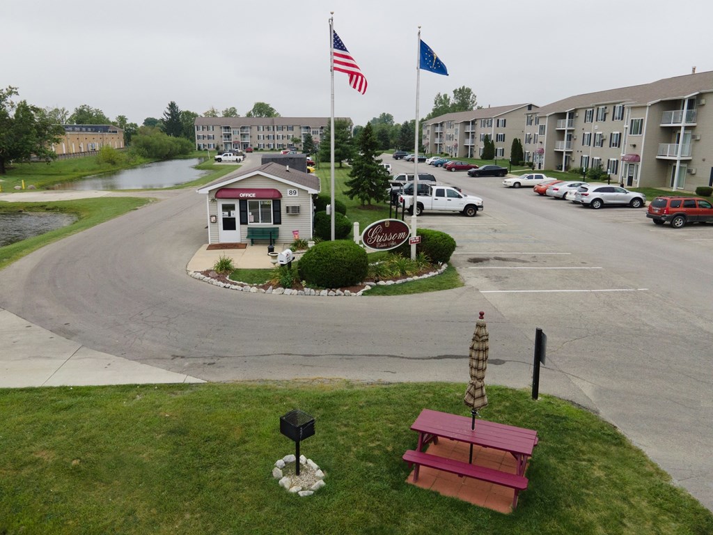 a red picnic bench sitting in front of a parking lot with an flag
