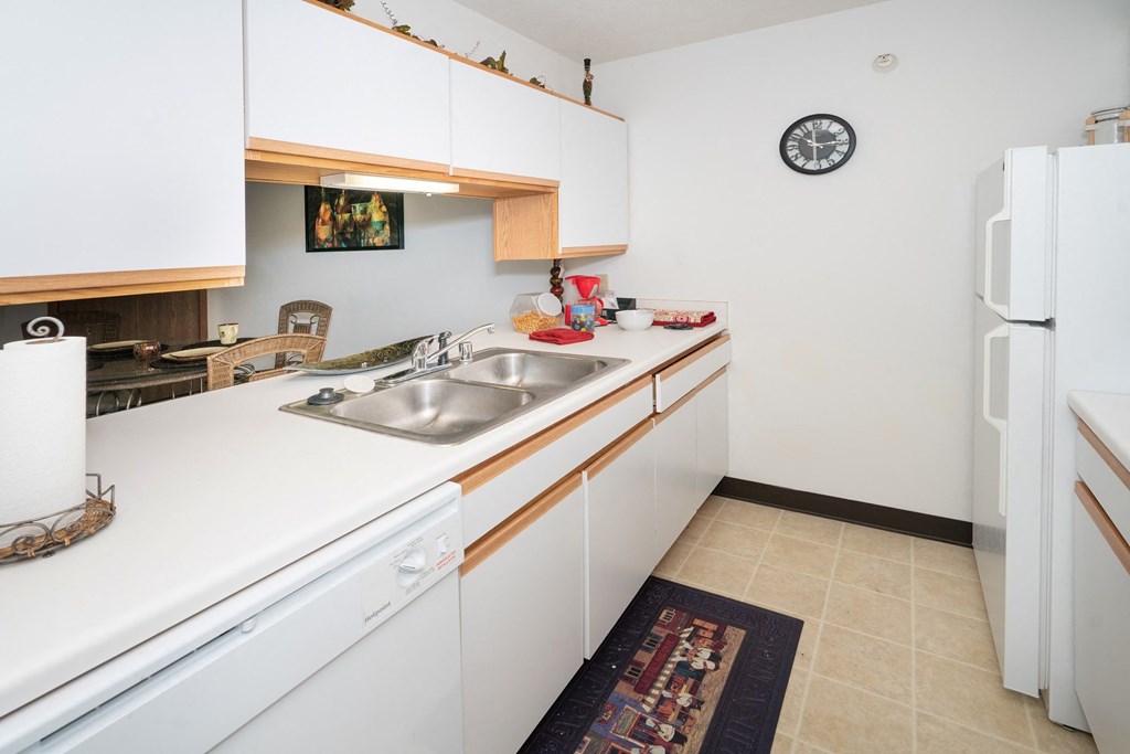 a kitchen with white cabinets and a sink and a refrigerator