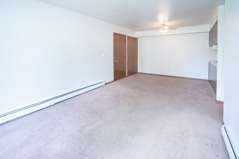 an empty living room with white walls and a concrete floor