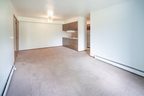 an empty living room with white walls and carpet