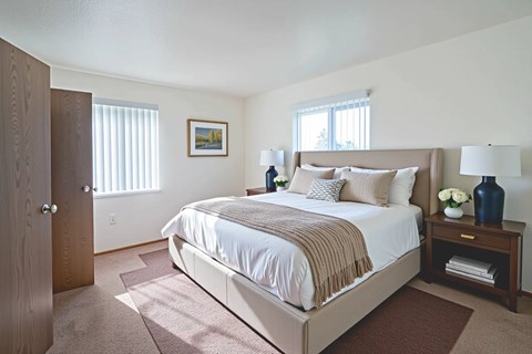 A bedroom with a large bed and a painting on the wall.
