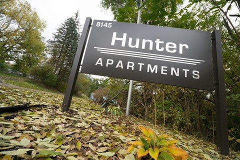 a sign for the hunter apartments on the side of a road