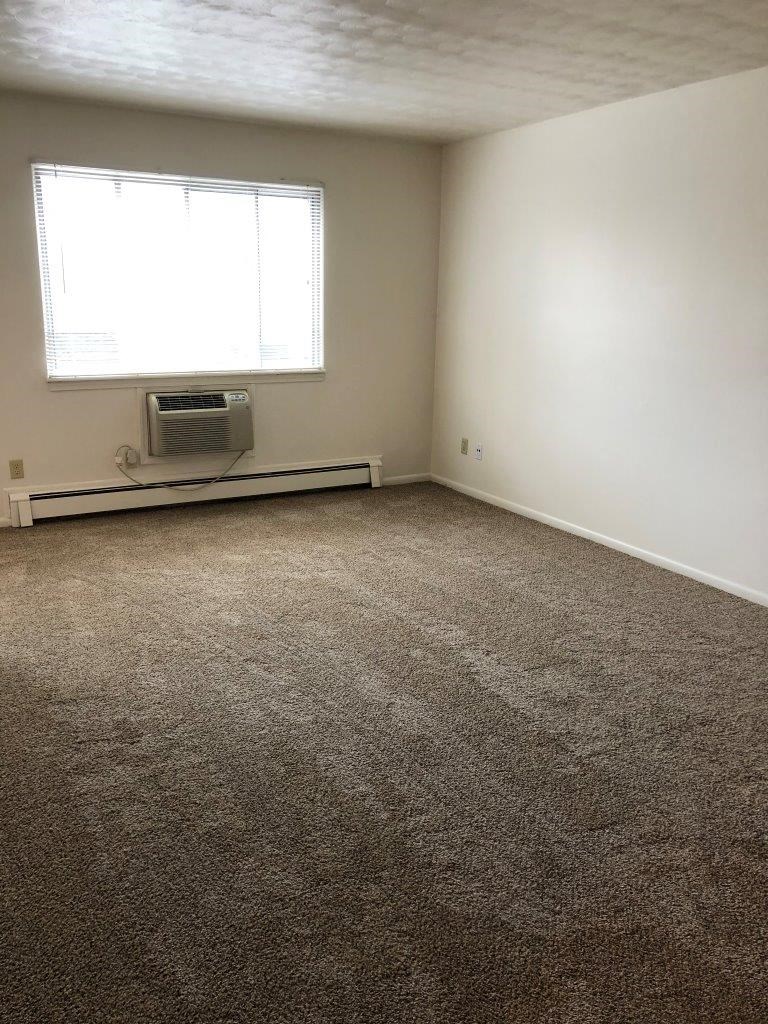 an empty room with a window and a radiator