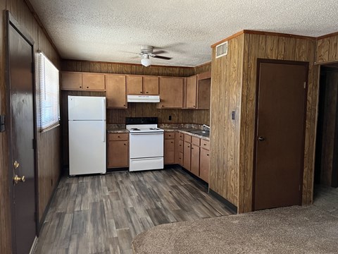 a kitchen with wooden cabinets and a white refrigerator